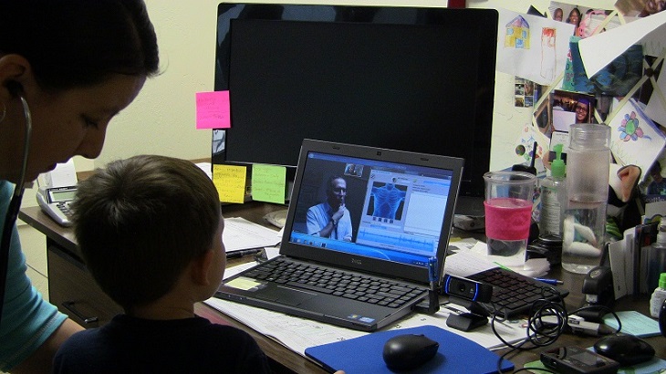 Physician uses telemedicine to listen to a child's lung sounds via digital stethoscope technology.  